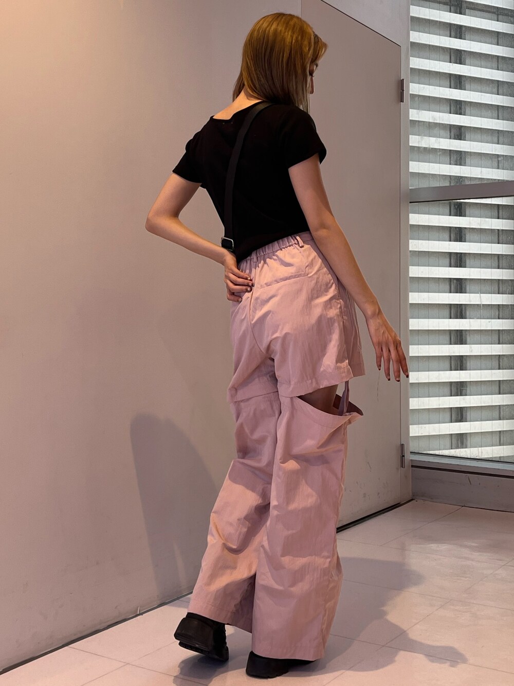 ピンク系のカーゴパンツ、シルバー系のボディバッグ/ウエストポーチ、ブラック系のTシャツ/カットソーを着用したレディースの春コーディネートの3枚目の写真