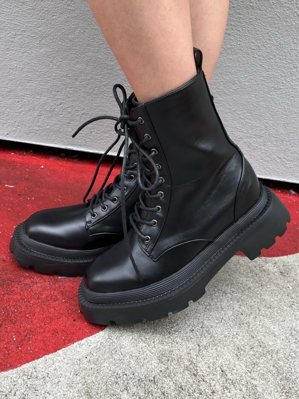 ブラック系のブーツ、ブラック系のボストンバッグ、ブラック系のスカートを着用したレディースの春コーディネートの8枚目の写真