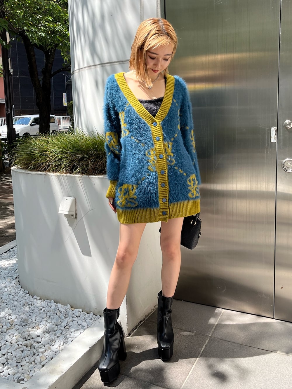 ブルー系のカーディガン/ボレロ、ブラック系のブーツ、ブラック系のショルダーバッグを着用したレディースの秋コーディネートの2枚目の写真