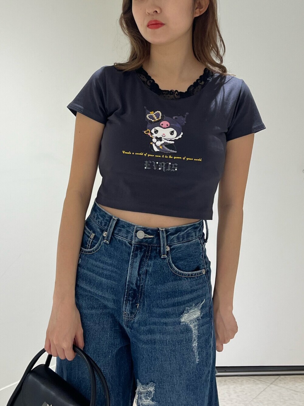 ブラック系のブーツ、ブルー系のデニムパンツ、ブラック系のハンドバッグを着用したレディースの春コーディネートの4枚目の写真