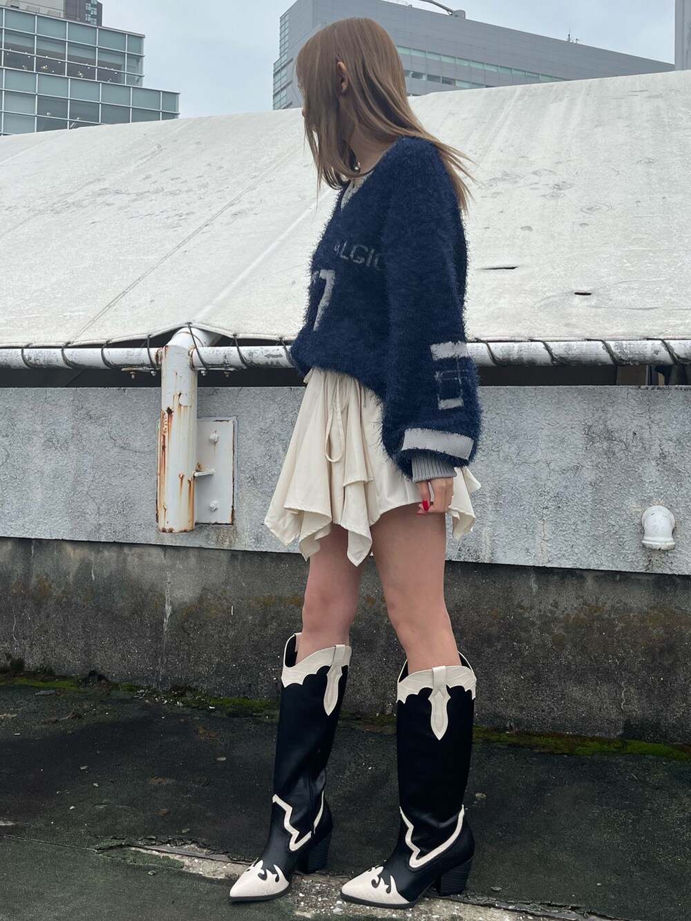 ホワイト系のスカート、ブラウン系のブーツ、ブルー系のニット/セーターを着用したレディースの秋コーディネートの2枚目の写真