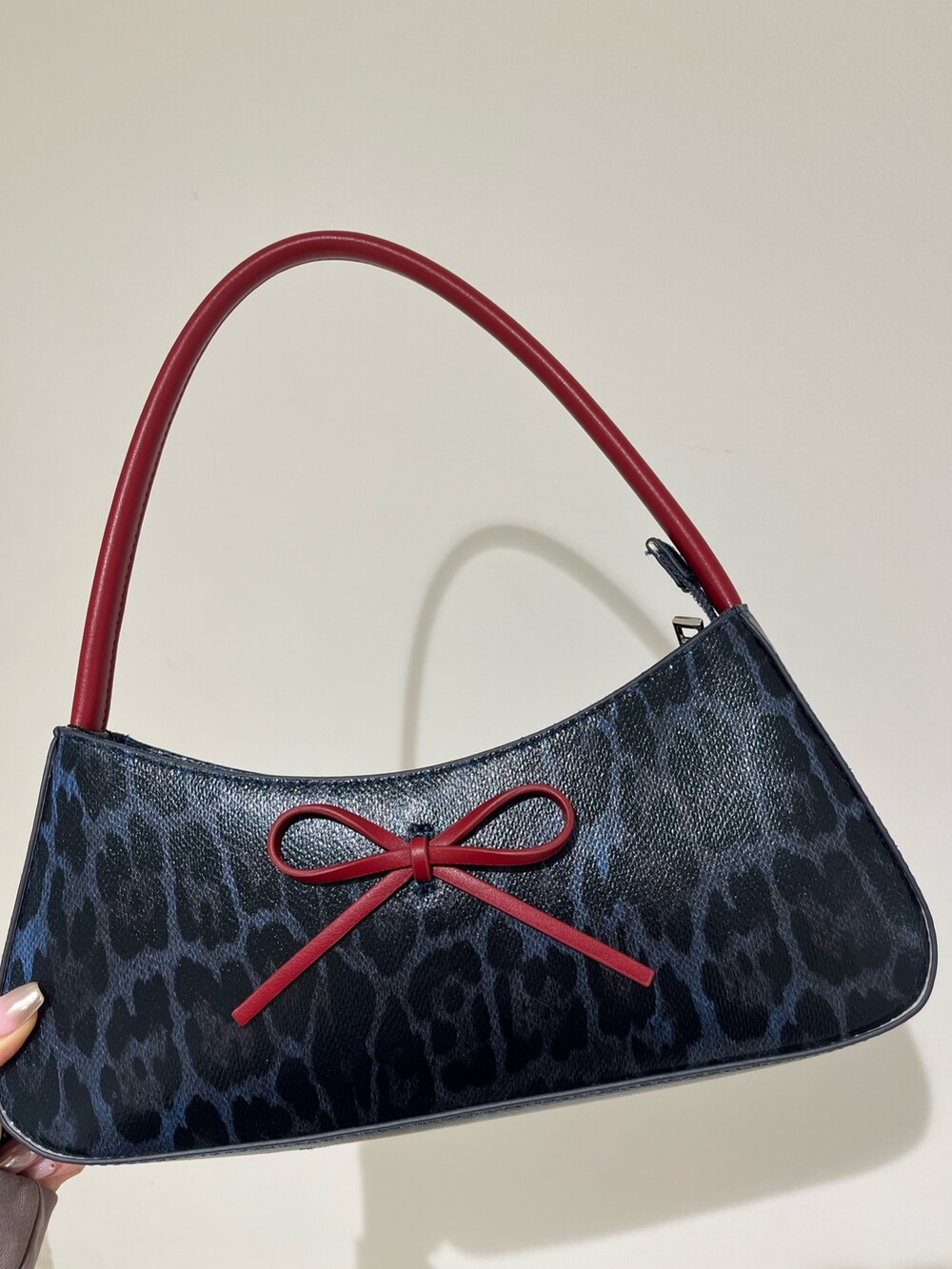 ブラック系のスウェット、ブラック系のスカート、ブラウン系のハンドバッグを着用したレディースの春コーディネートの7枚目の写真