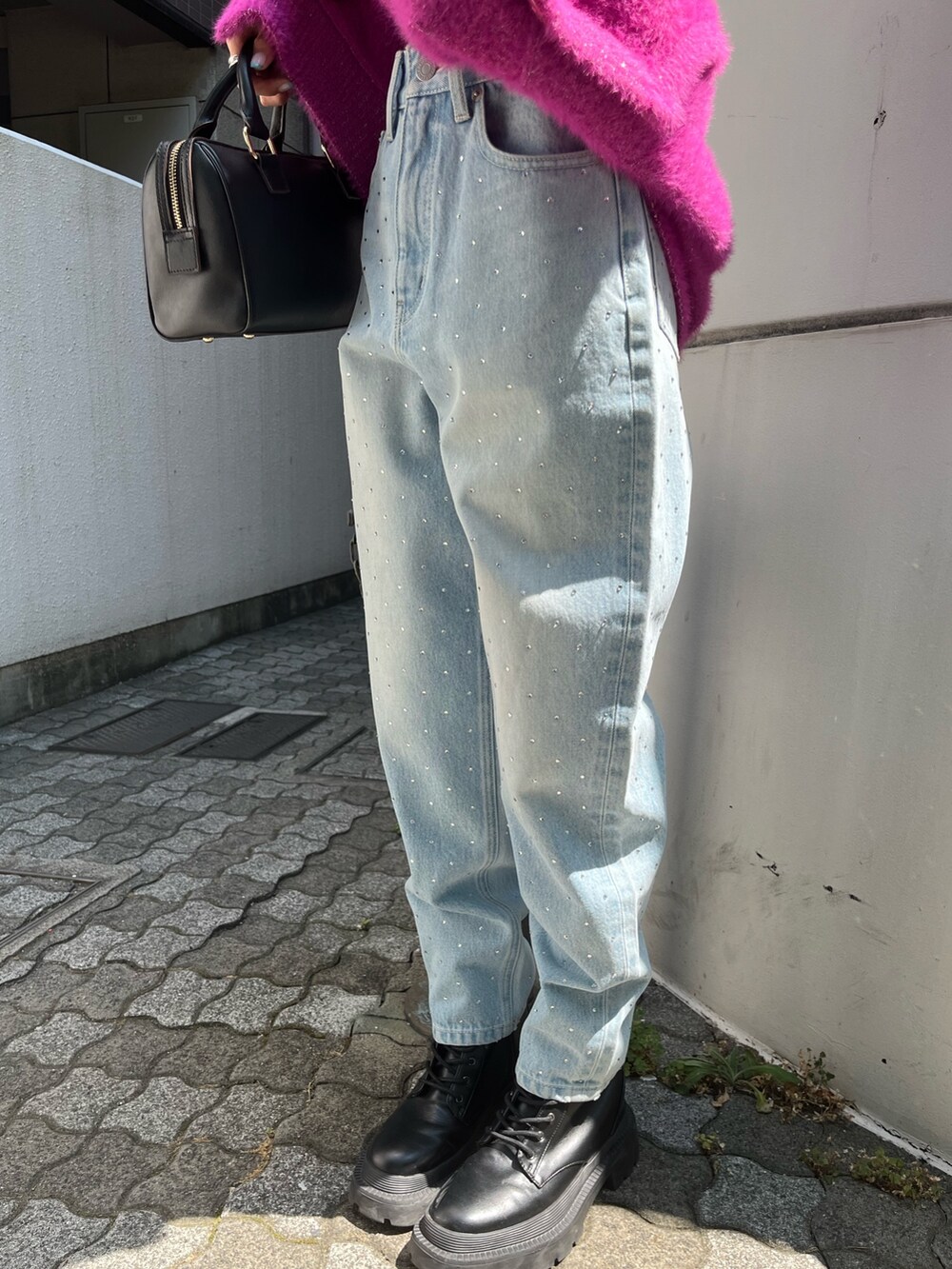 ブルー系のデニムパンツ、レッド系のニット/セーター、ブルー系のハンドバッグを着用したレディースの秋コーディネートの7枚目の写真