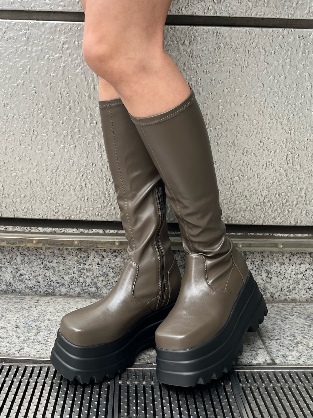 ブラック系のブーツ、ブラック系のTシャツ/カットソー、ブラック系のデニムスカートを着用したレディースの冬コーディネートの7枚目の写真