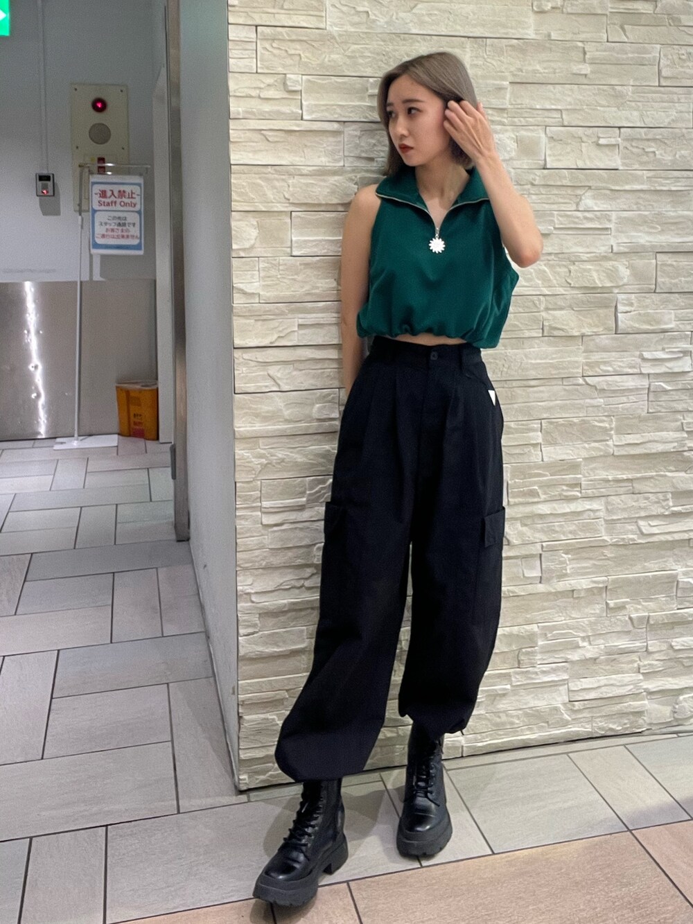 ブラック系のタンクトップ、パープル系のカーゴパンツ、ブラック系のブーツを着用したレディースの春コーディネートの2枚目の写真