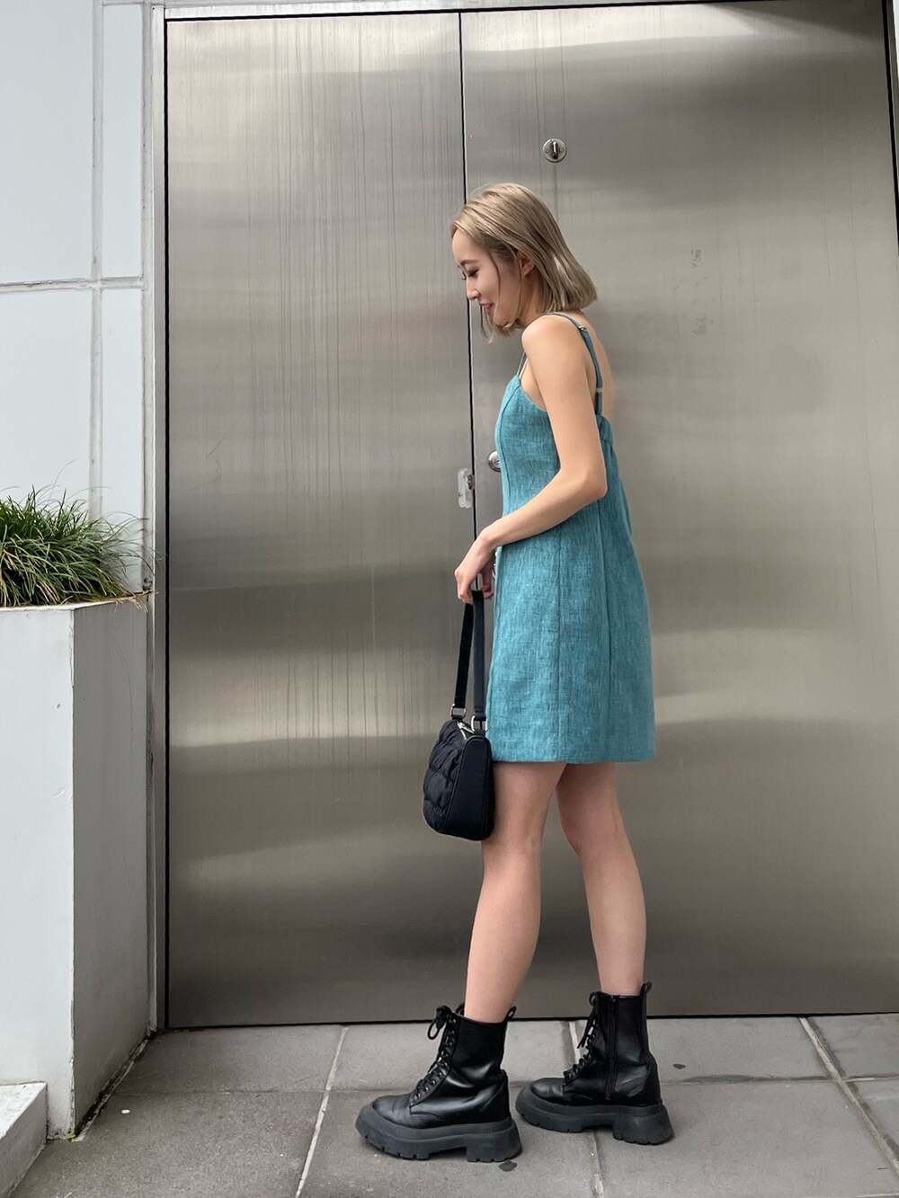 ホワイト系のブーツ、ブルー系のワンピース、シルバー系のネックレスを着用したレディースの春コーディネートの2枚目の写真