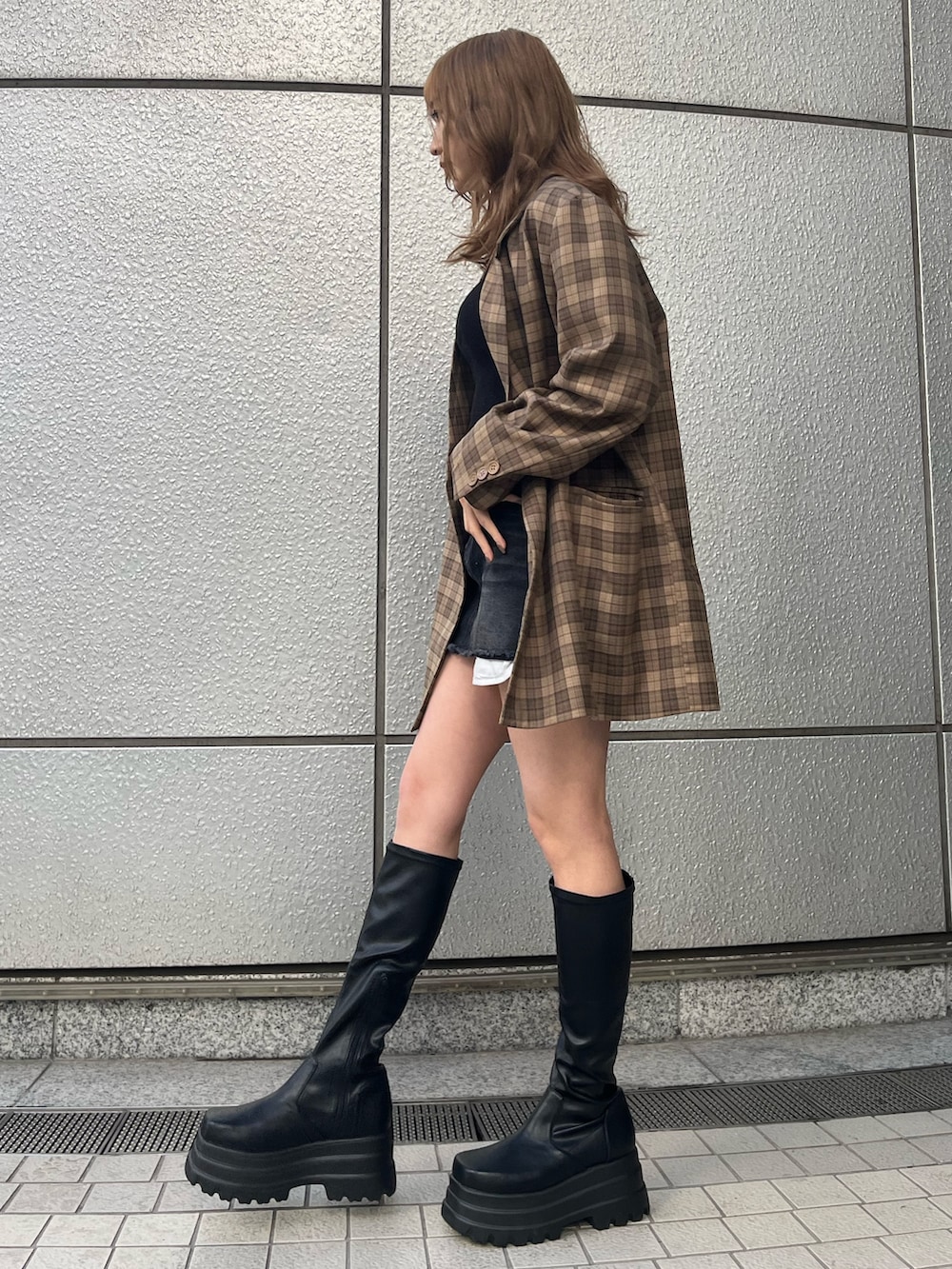 ブラック系のブーツ、ブラック系のTシャツ/カットソー、ブラック系のデニムスカートを着用したレディースの冬コーディネートの2枚目の写真