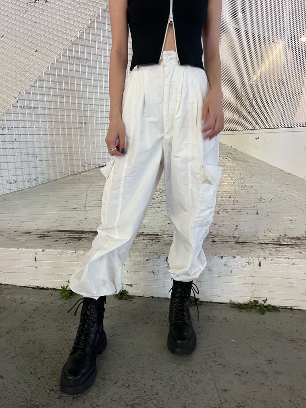 ホワイト系のカーゴパンツ、ブラック系のタンクトップ、ホワイト系のブーツを着用したレディースの夏コーディネートの8枚目の写真