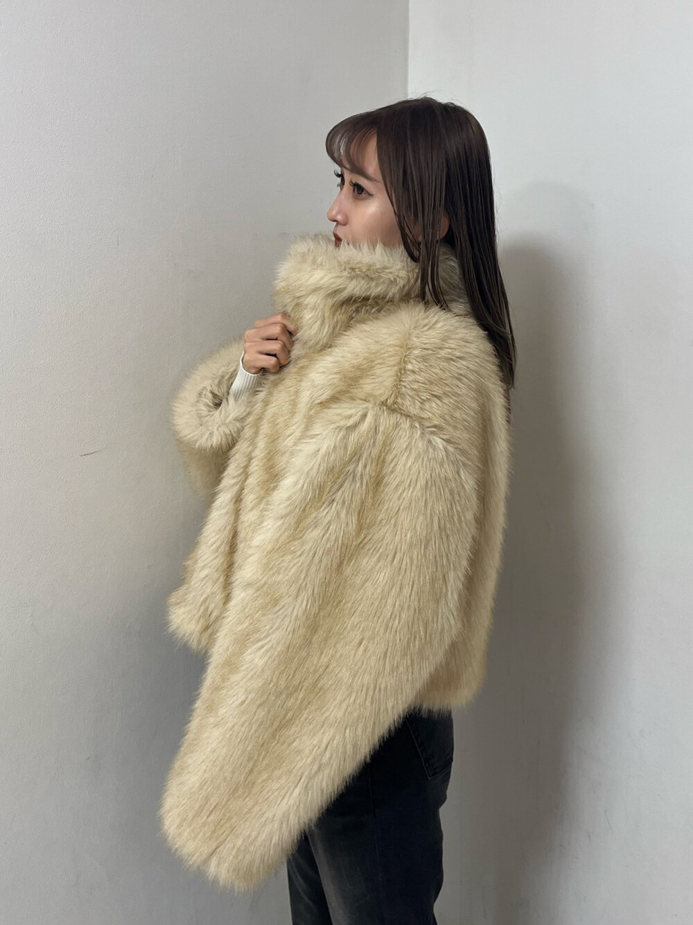 ベージュ系のブルゾン、ホワイト系のニット/セーター、ブラック系のデニムパンツを着用したレディースの冬コーディネートの4枚目の写真