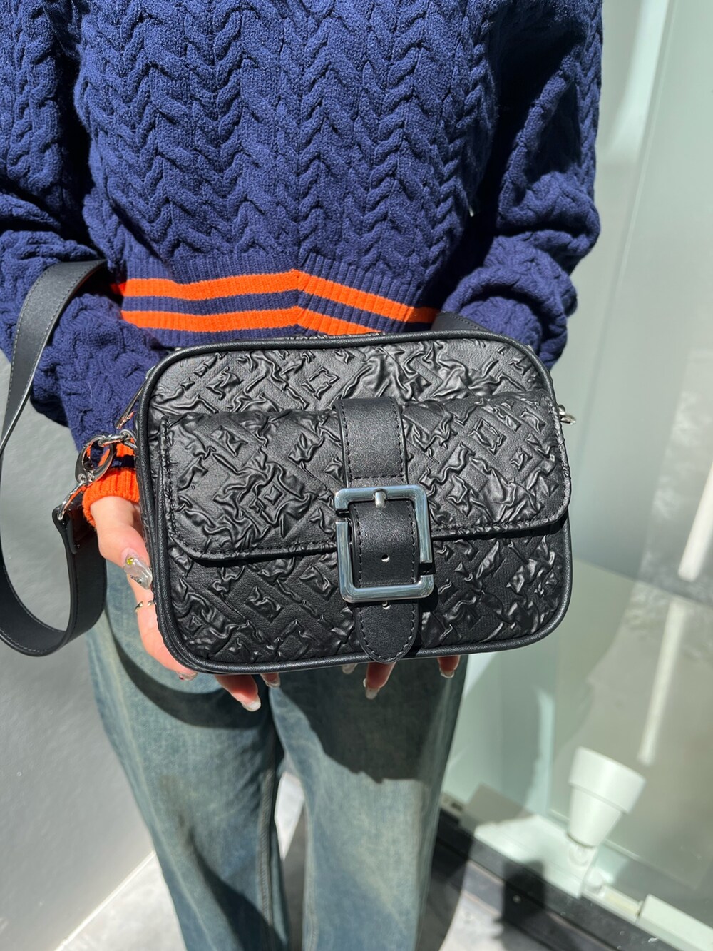 ブルー系のニット/セーター、ブルー系のデニムパンツを着用したレディースの秋コーディネートの6枚目の写真