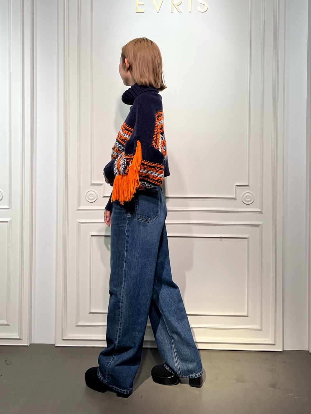 ブルー系のニット/セーター、ブラック系のブーツ、ブラック系のデニムパンツを着用したレディースの秋コーディネートの2枚目の写真