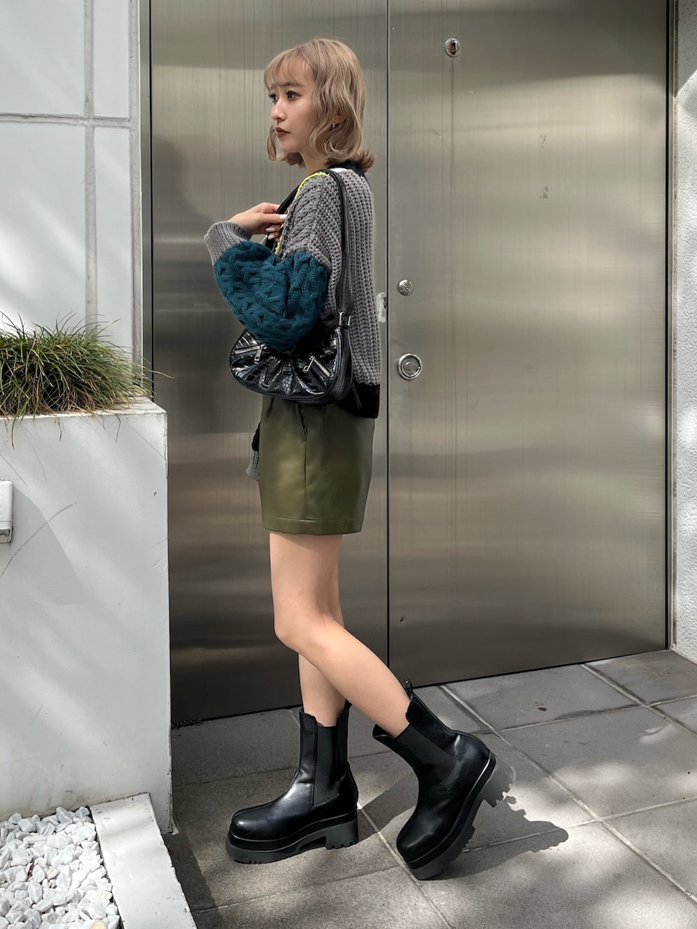 ホワイト系のブーツ、ブラック系のショルダーバッグ、ブラック系のニット/セーターを着用したレディースの秋コーディネートの3枚目の写真