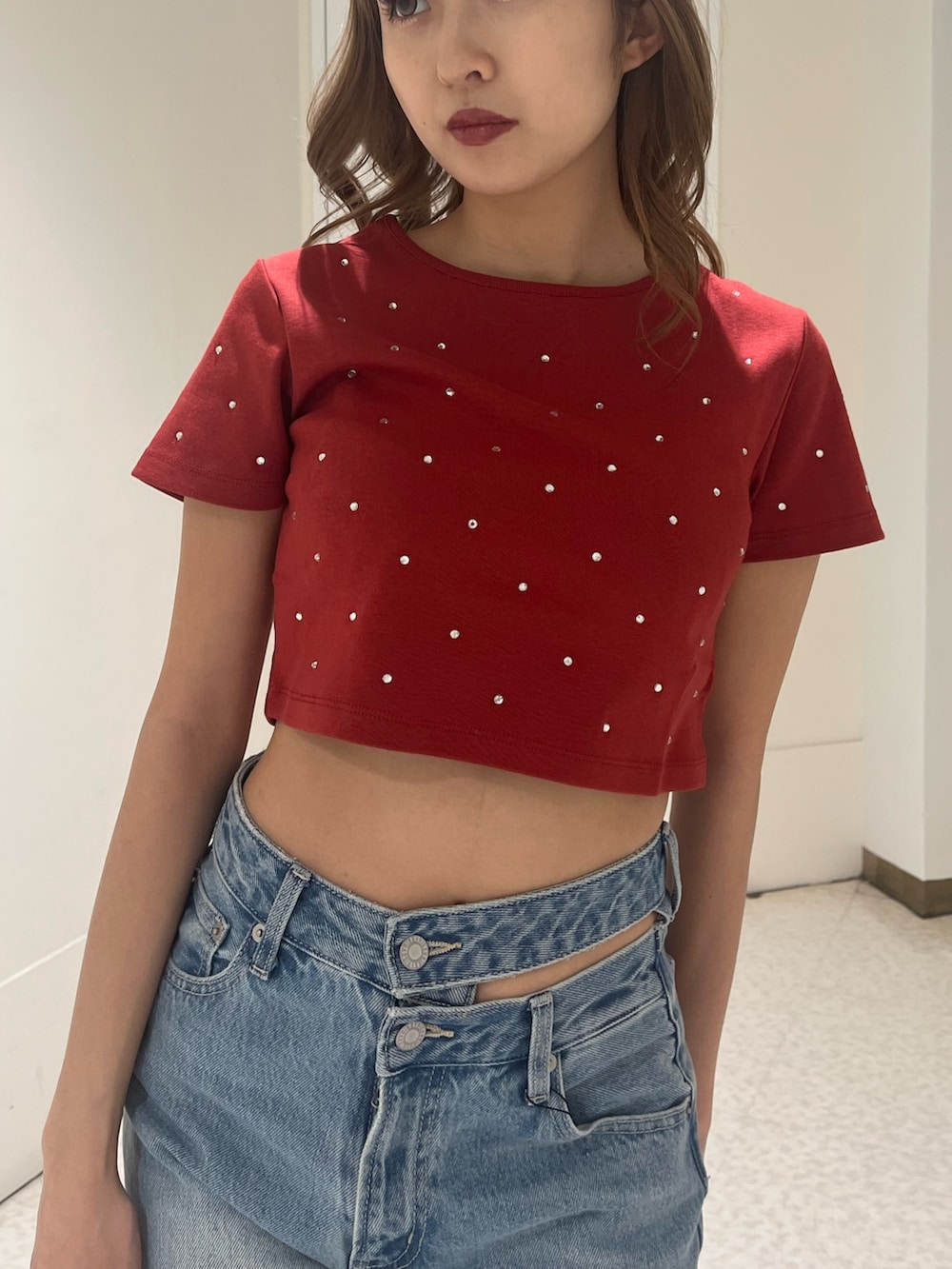 ブルー系のデニムパンツ、ブラウン系のハンドバッグ、ブラック系のブーツを着用したレディースの春コーディネートの4枚目の写真