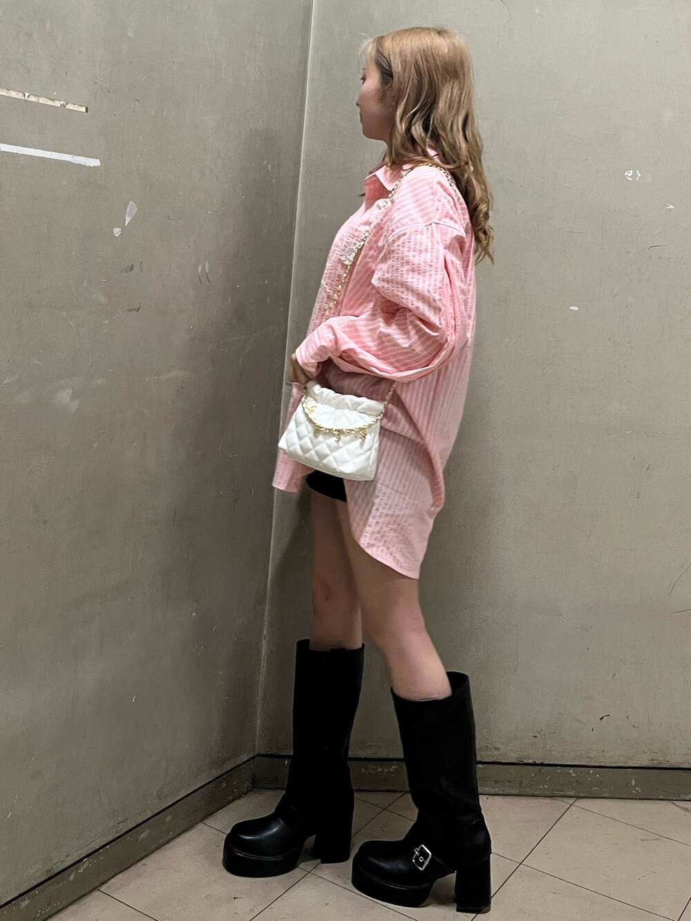 グリーン系のシャツ/ブラウス、ホワイト系のショルダーバッグ、ブラック系のブーツを着用したレディースの春コーディネートの2枚目の写真