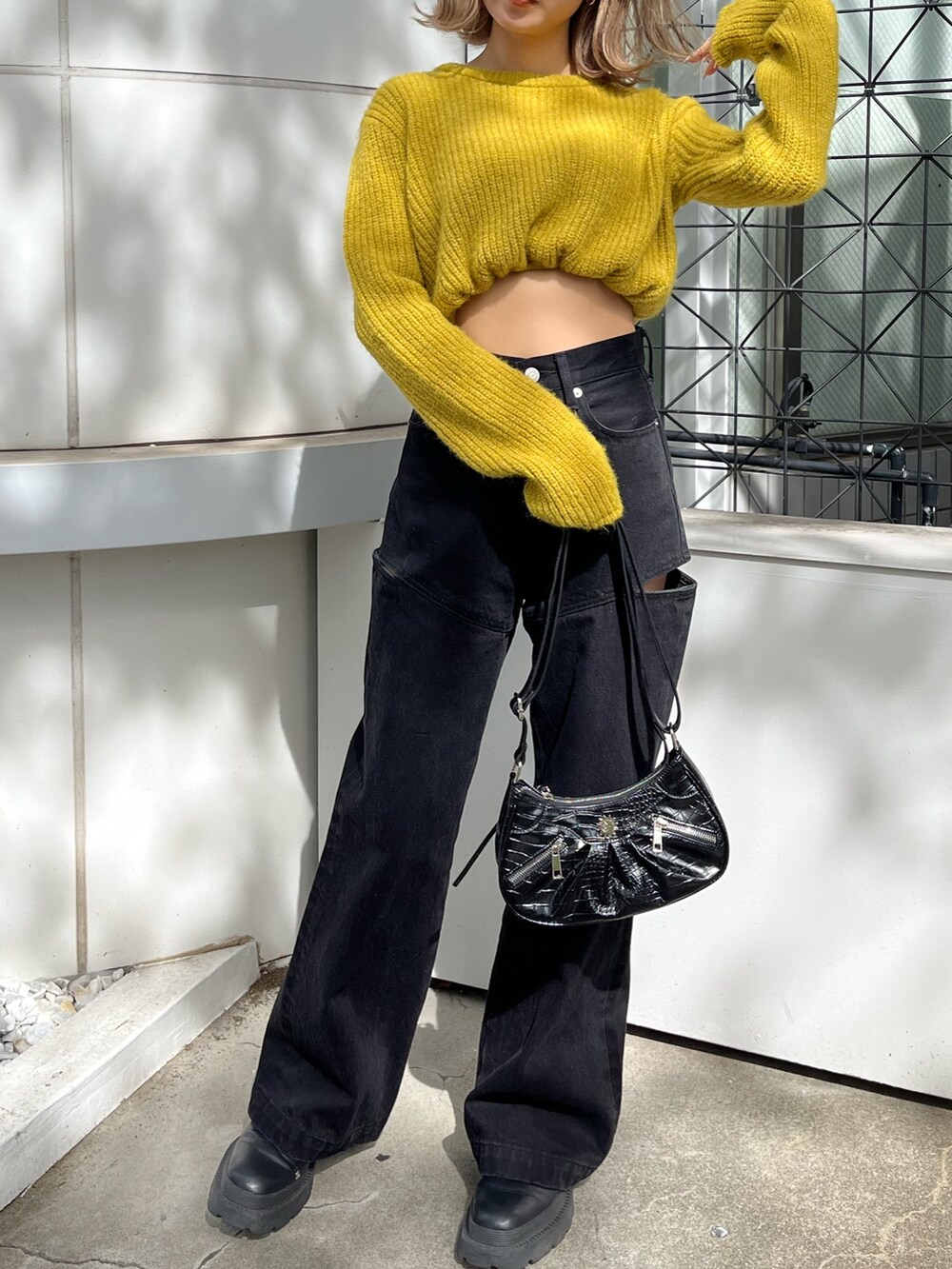 ブラック系のショルダーバッグ、ブラック系のデニムパンツ、イエロー系のニット/セーターを着用したレディースの秋コーディネートの8枚目の写真