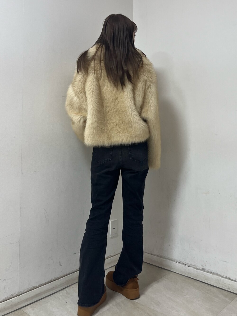 ベージュ系のブルゾン、ホワイト系のニット/セーター、ブラック系のデニムパンツを着用したレディースの冬コーディネートの2枚目の写真