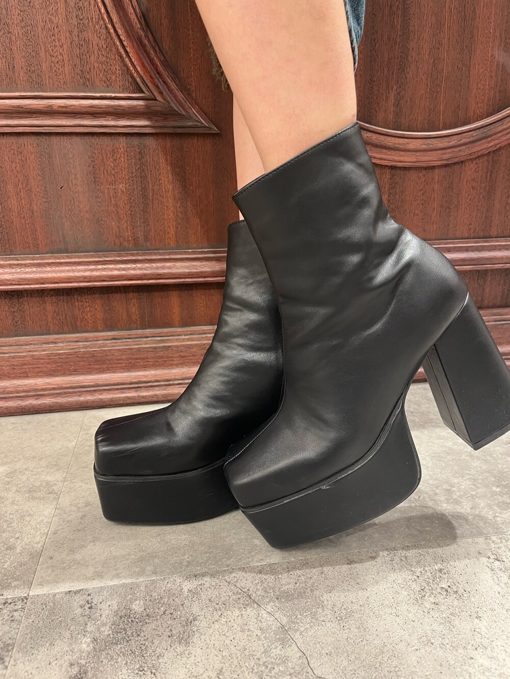 ブラック系のブーツ、レッド系のニット/セーター、ブルー系のデニムパンツを着用したレディースの冬コーディネートの7枚目の写真