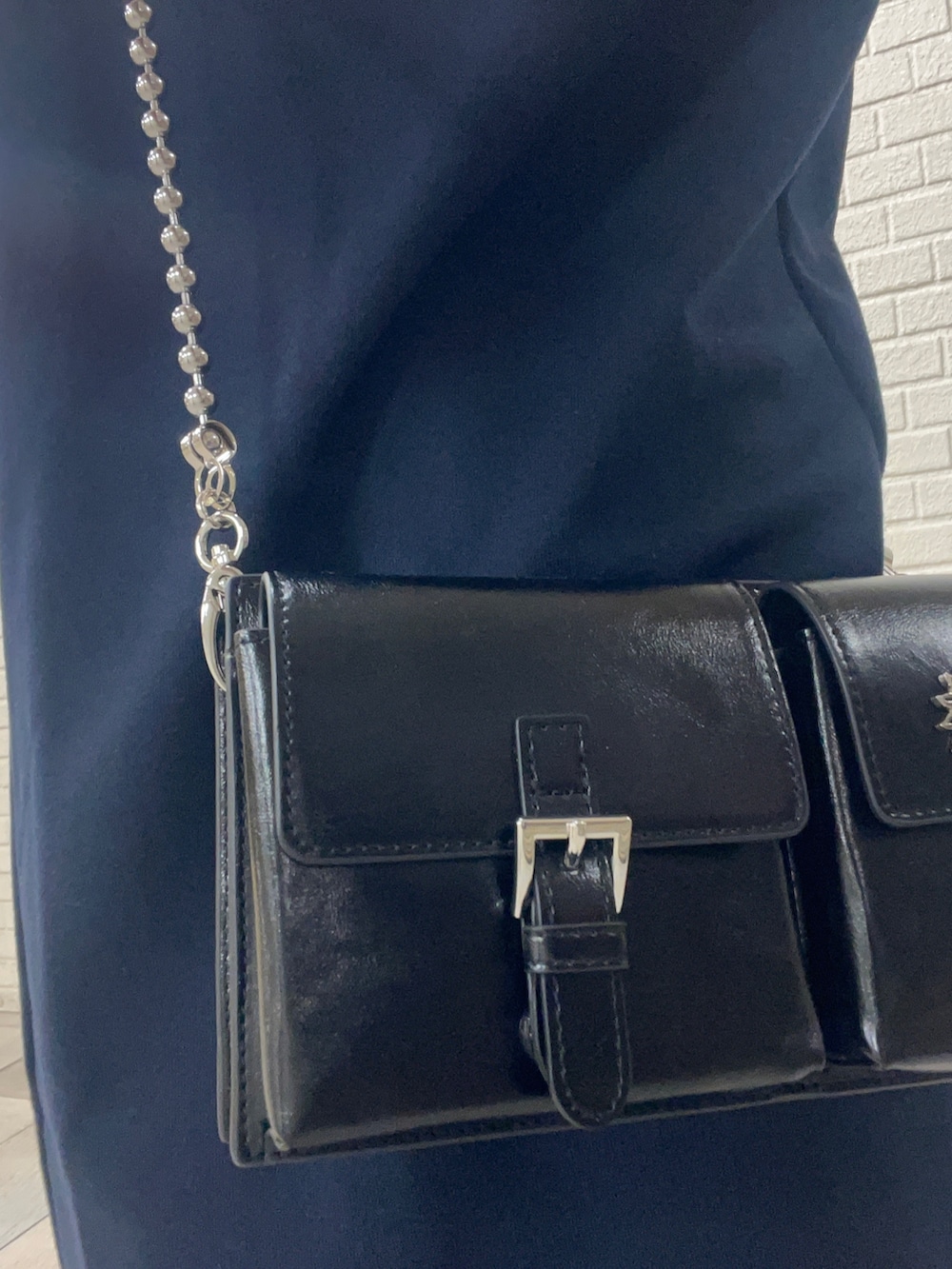 ブルー系のショルダーバッグ、ブルー系のワンピース、ホワイト系のブーツを着用したレディースの秋コーディネートの6枚目の写真