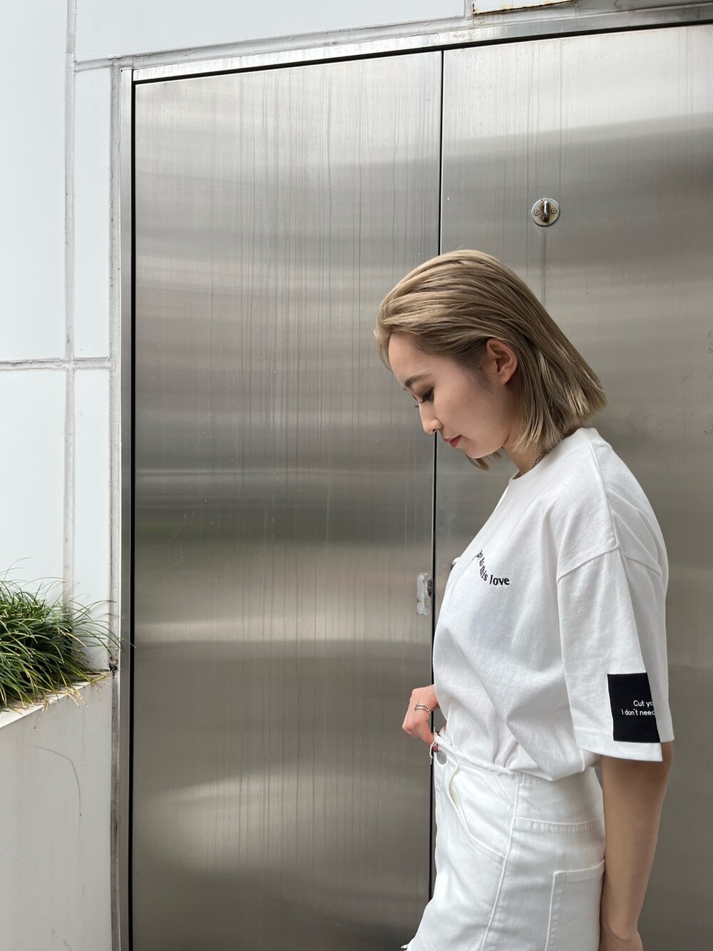 ホワイト系のデニムパンツ、ホワイト系のTシャツ/カットソー、ブラック系のスニーカーを着用したレディースの春コーディネートの5枚目の写真