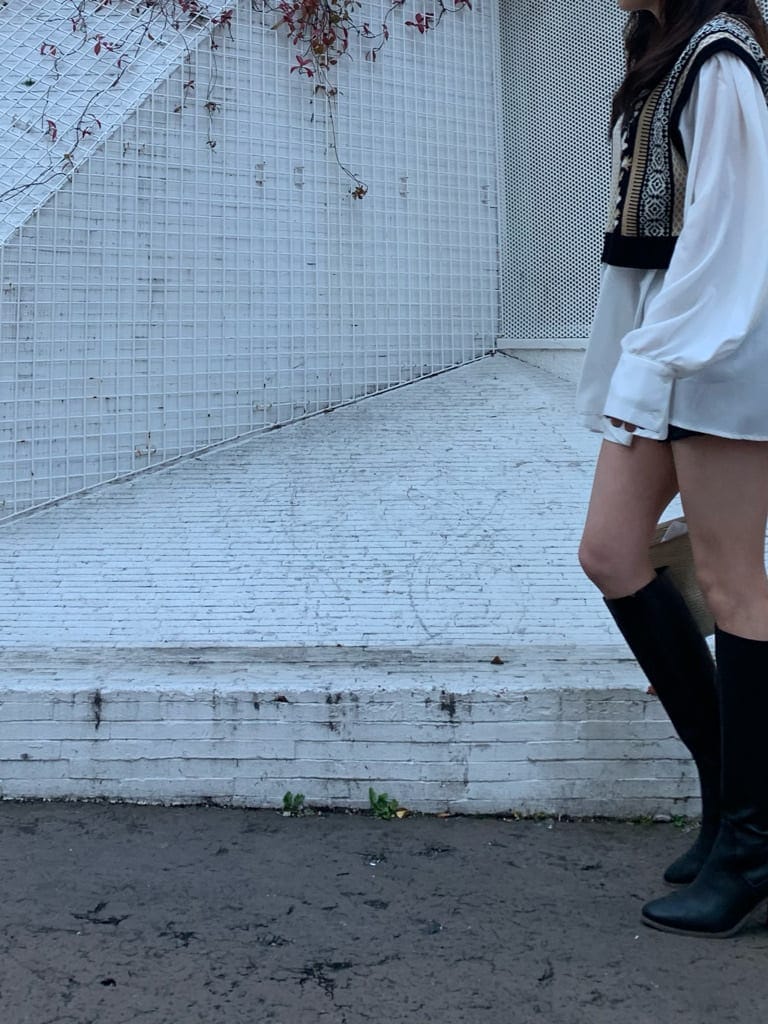 ホワイト系のショルダーバッグ、ブラック系のブーツ、ブラック系のシャツ/ブラウスを着用したレディースの冬コーディネートの6枚目の写真