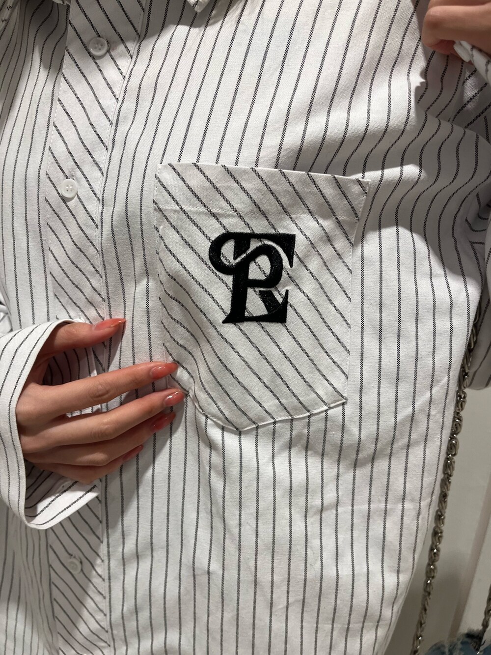 ホワイト系のシャツ/ブラウス、ブルー系のショルダーバッグ、ブラック系のブーツを着用したレディースの冬コーディネートの6枚目の写真