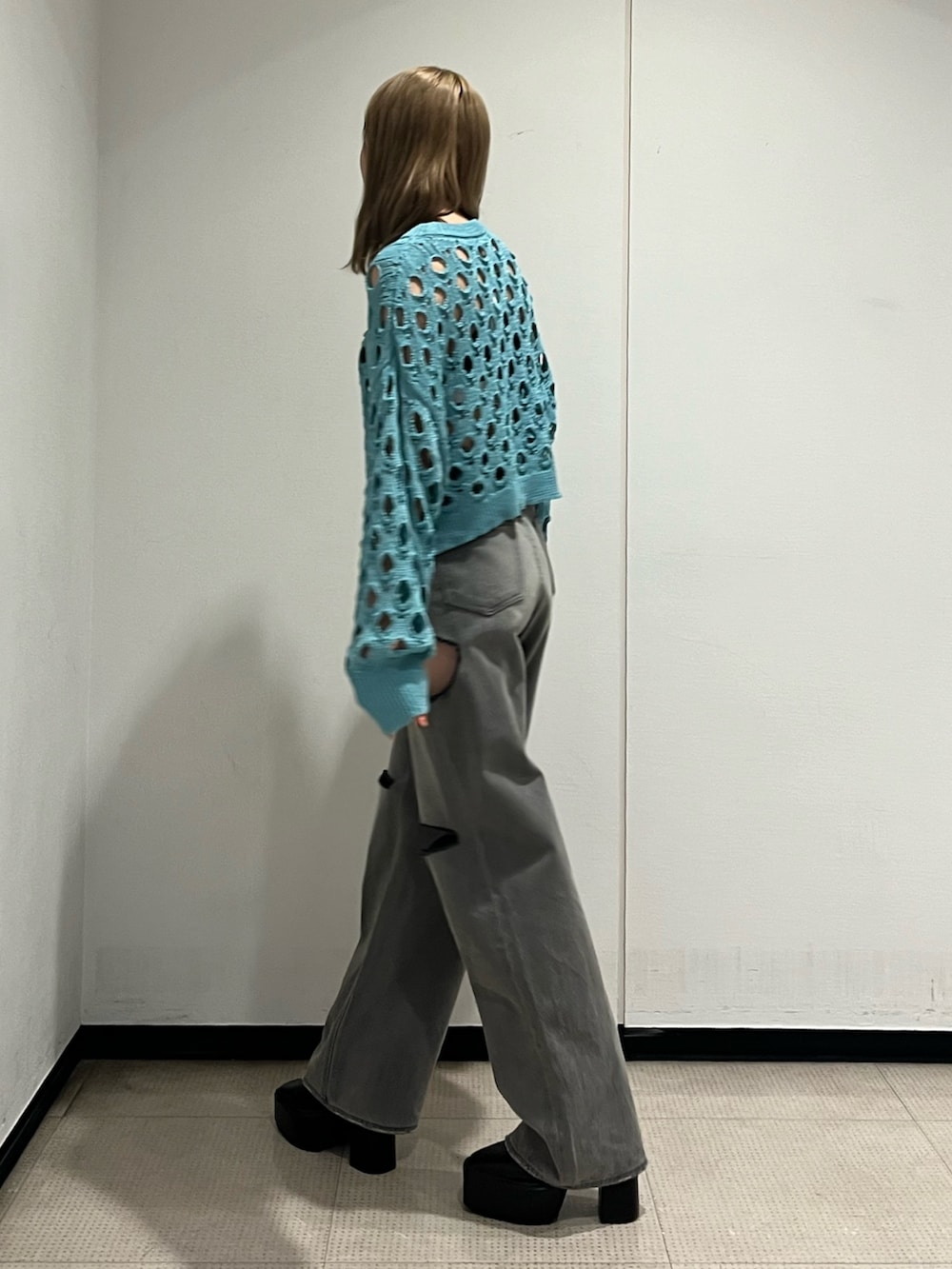 ブラック系のデニムパンツ、ブラック系のブーツ、ブルー系のニット/セーターを着用したレディースの冬コーディネートの3枚目の写真