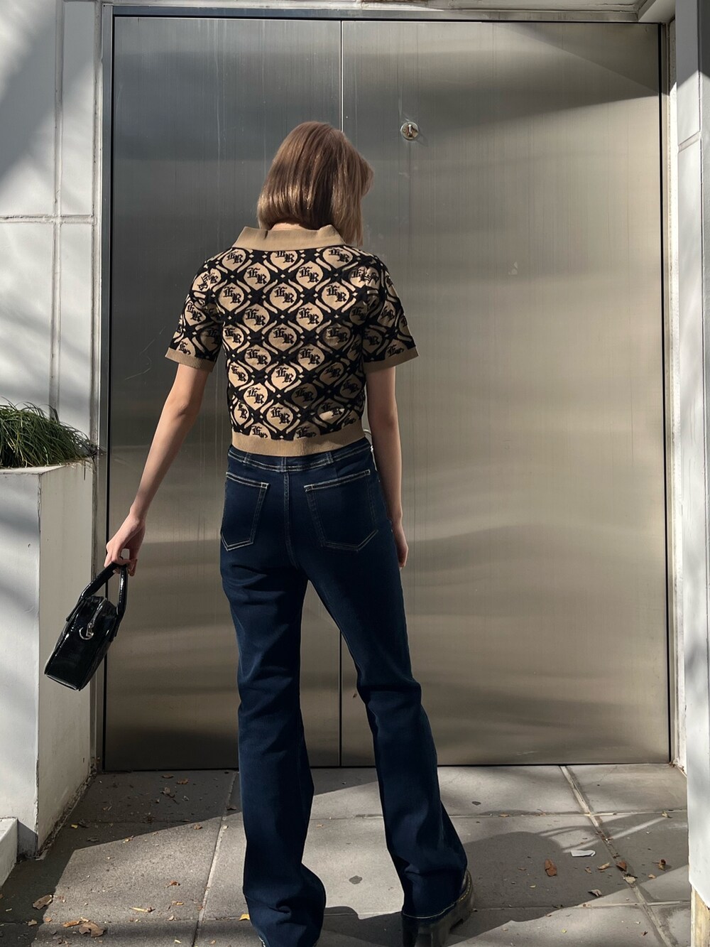 ブルー系のショルダーバッグ、ブルー系のデニムパンツ、ベージュ系のニット/セーターを着用したレディースの冬コーディネートの3枚目の写真