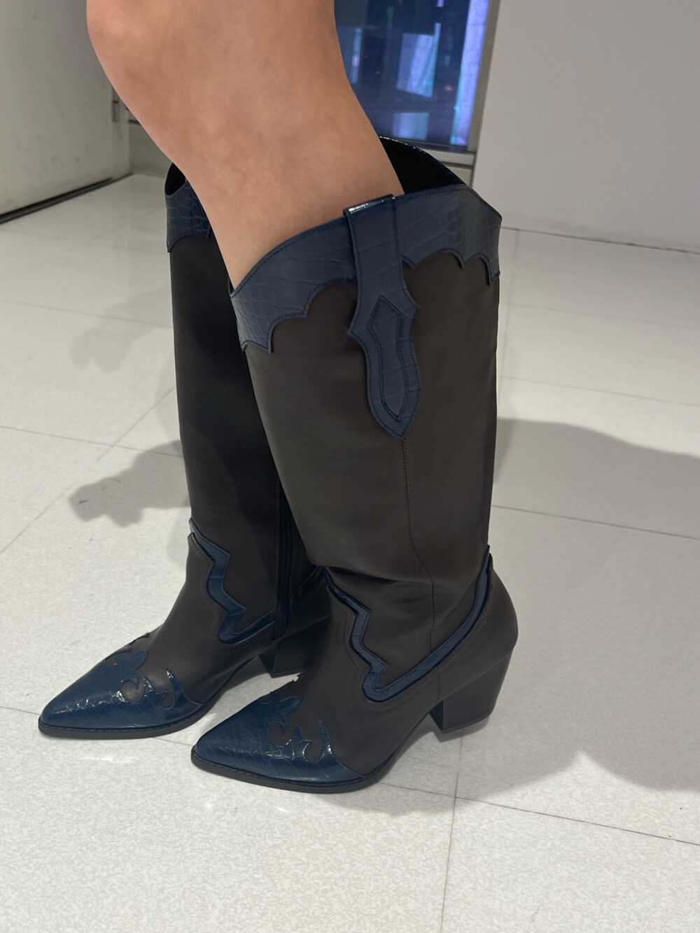 ブラック系のハンドバッグ、グレー系のTシャツ/カットソー、ブラウン系のブーツを着用したレディースの秋コーディネートの7枚目の写真