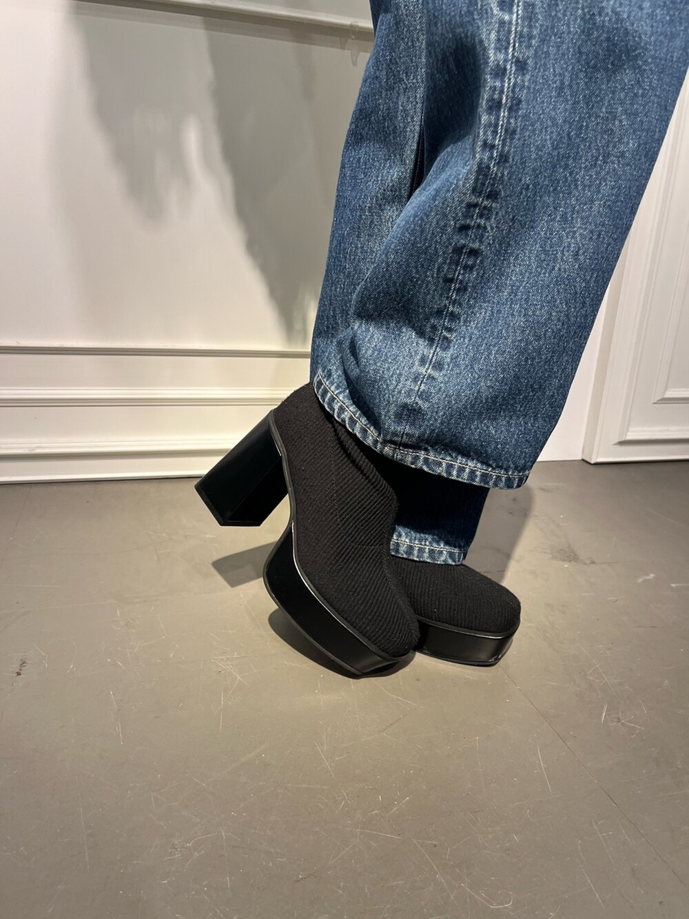 ブルー系のニット/セーター、ブラック系のブーツ、ブラック系のデニムパンツを着用したレディースの秋コーディネートの7枚目の写真