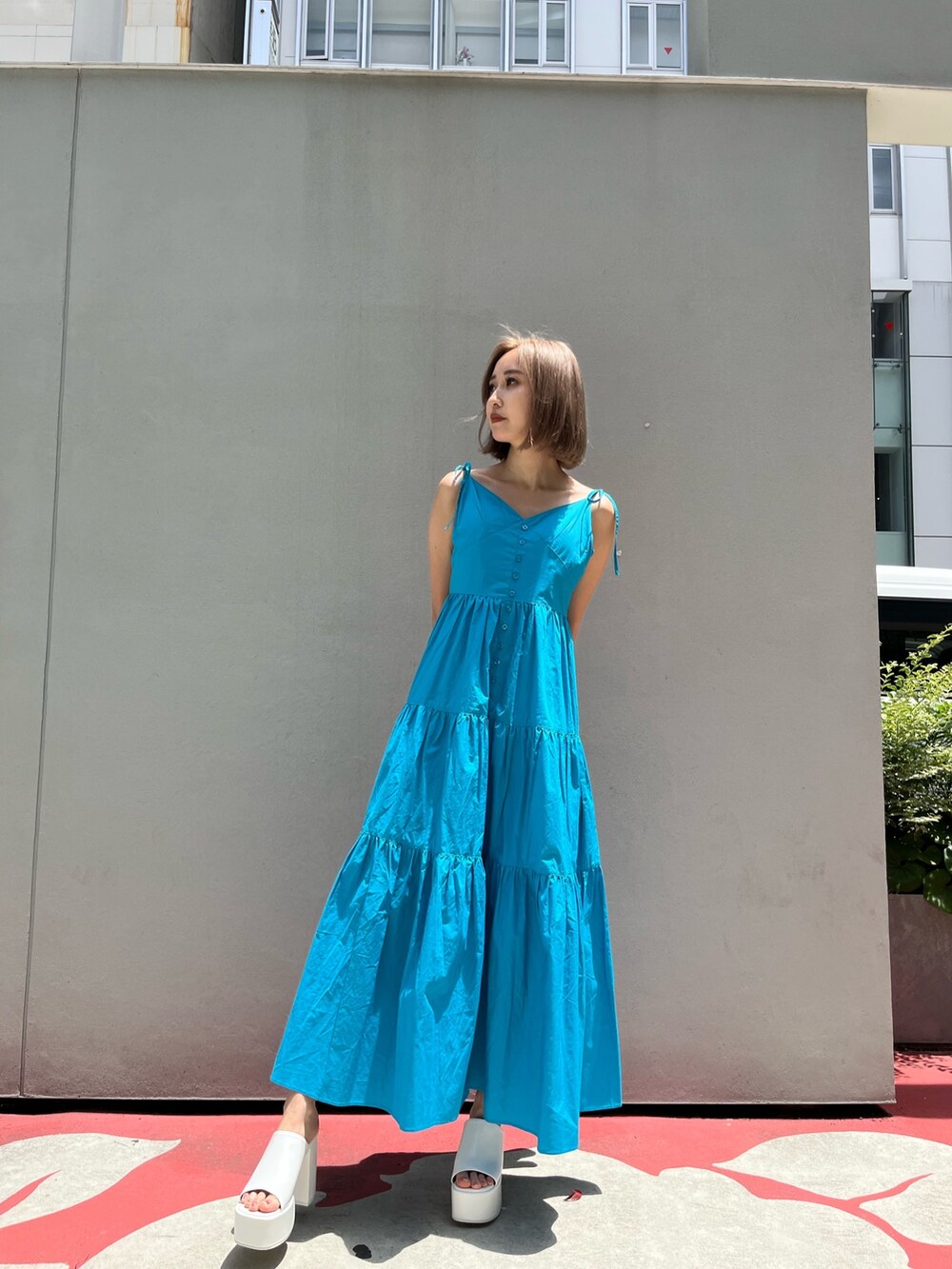 ホワイト系のサンダル、ブラック系のワンピースを着用したレディースの夏コーディネートの2枚目の写真