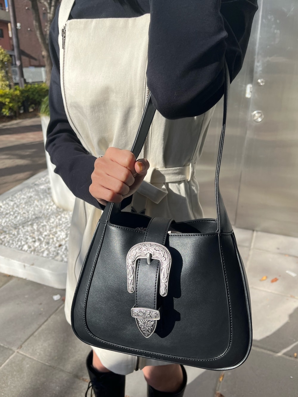 ブルー系のデニムジャケット、ブラック系のハンドバッグ、ブルー系のデニムパンツを着用したレディースの冬コーディネートの7枚目の写真