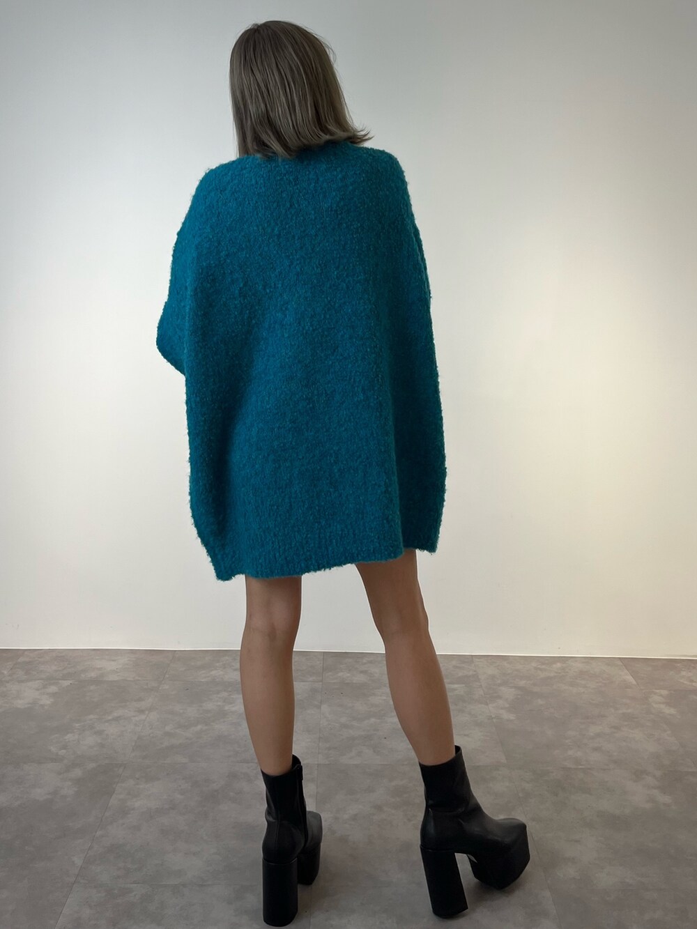 ブルー系のニット/セーター、ブラック系のブーツを着用したレディースの冬コーディネートの5枚目の写真