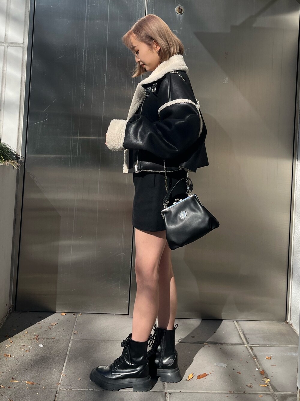 ブラック系のブルゾン、グレー系のTシャツ/カットソー、ブラック系のブーツを着用したレディースの冬コーディネートの2枚目の写真