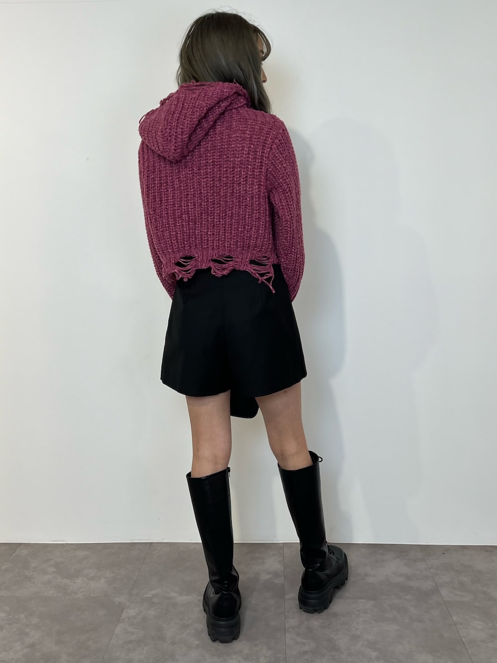パープル系のニット/セーター、ブラック系のその他パンツ、ブラック系のブーツを着用したレディースの冬コーディネートの3枚目の写真