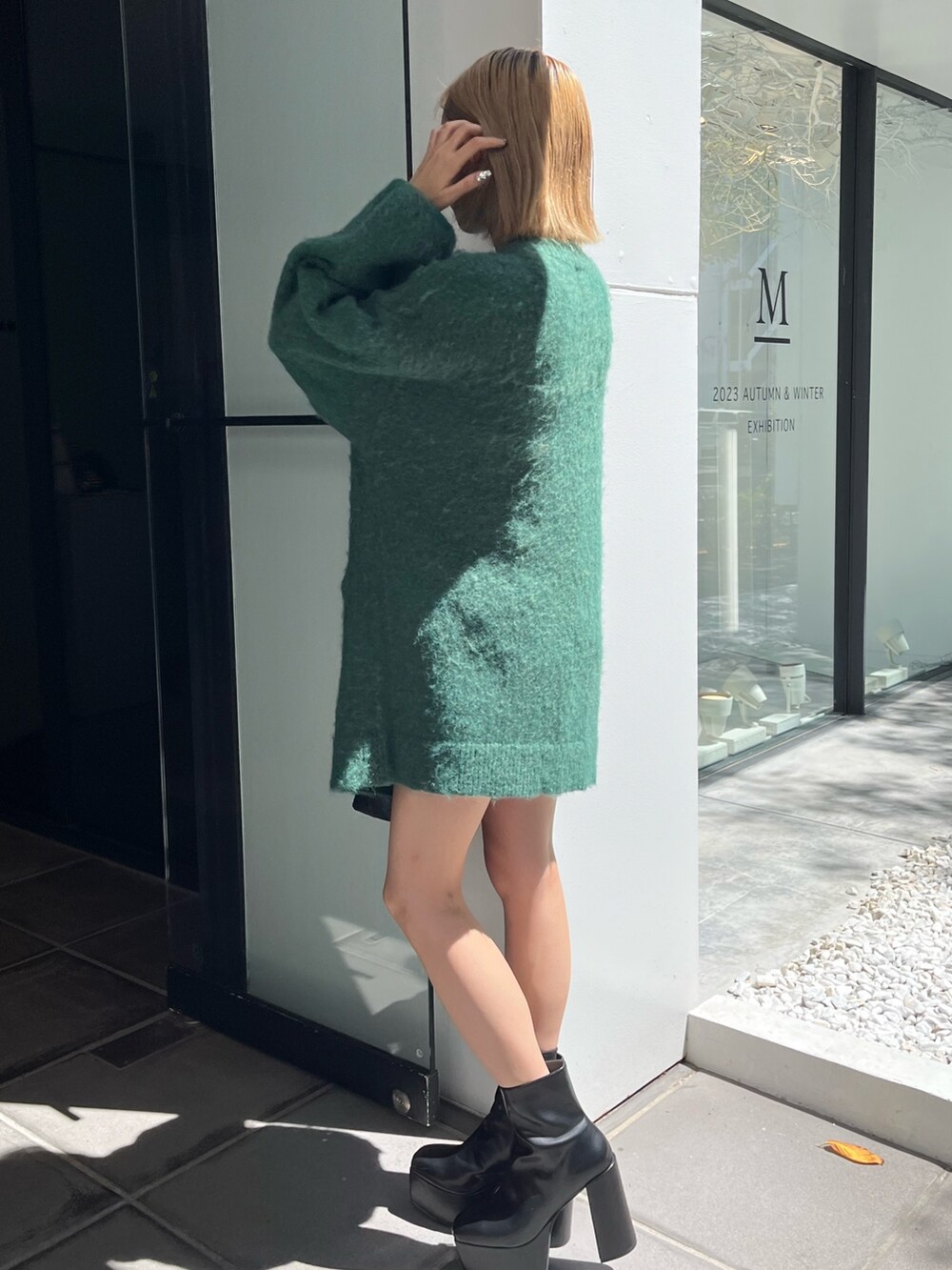 ブラック系のブーツ、ブラック系のショルダーバッグ、グリーン系のカーディガン/ボレロを着用したレディースの秋コーディネートの3枚目の写真