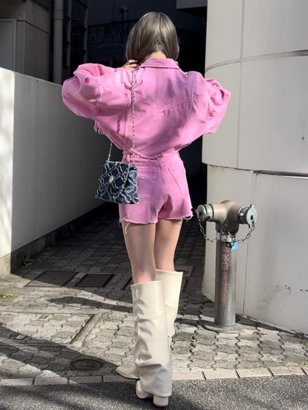 ピンク系のデニムジャケット、ピンク系のデニムパンツ、ホワイト系のブーツを着用したレディースの冬コーディネートの7枚目の写真