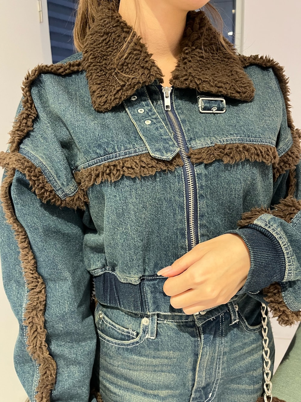 ブルー系のブルゾン、ブルー系のデニムパンツ、ブラック系のブーツを着用したレディースの秋コーディネートの5枚目の写真