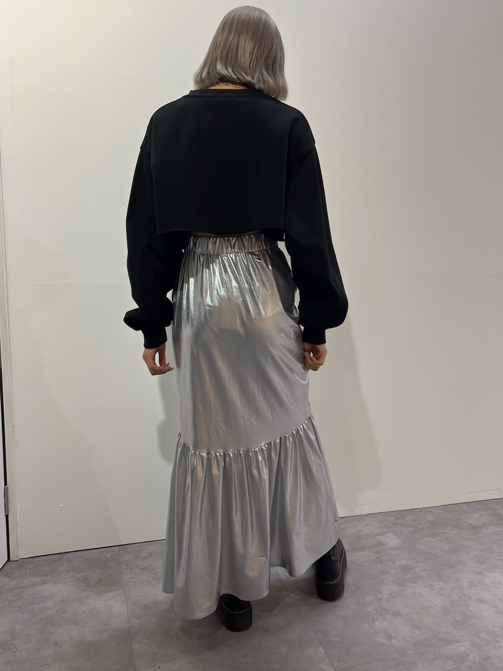 シルバー系のスカート、ホワイト系のスウェットを着用したレディースの秋コーディネートの7枚目の写真