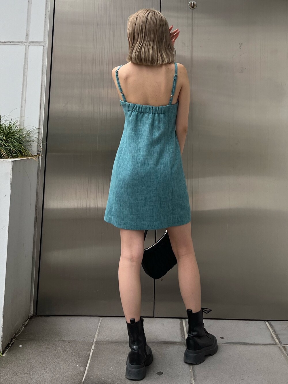 ホワイト系のブーツ、ブルー系のワンピース、シルバー系のネックレスを着用したレディースの春コーディネートの3枚目の写真