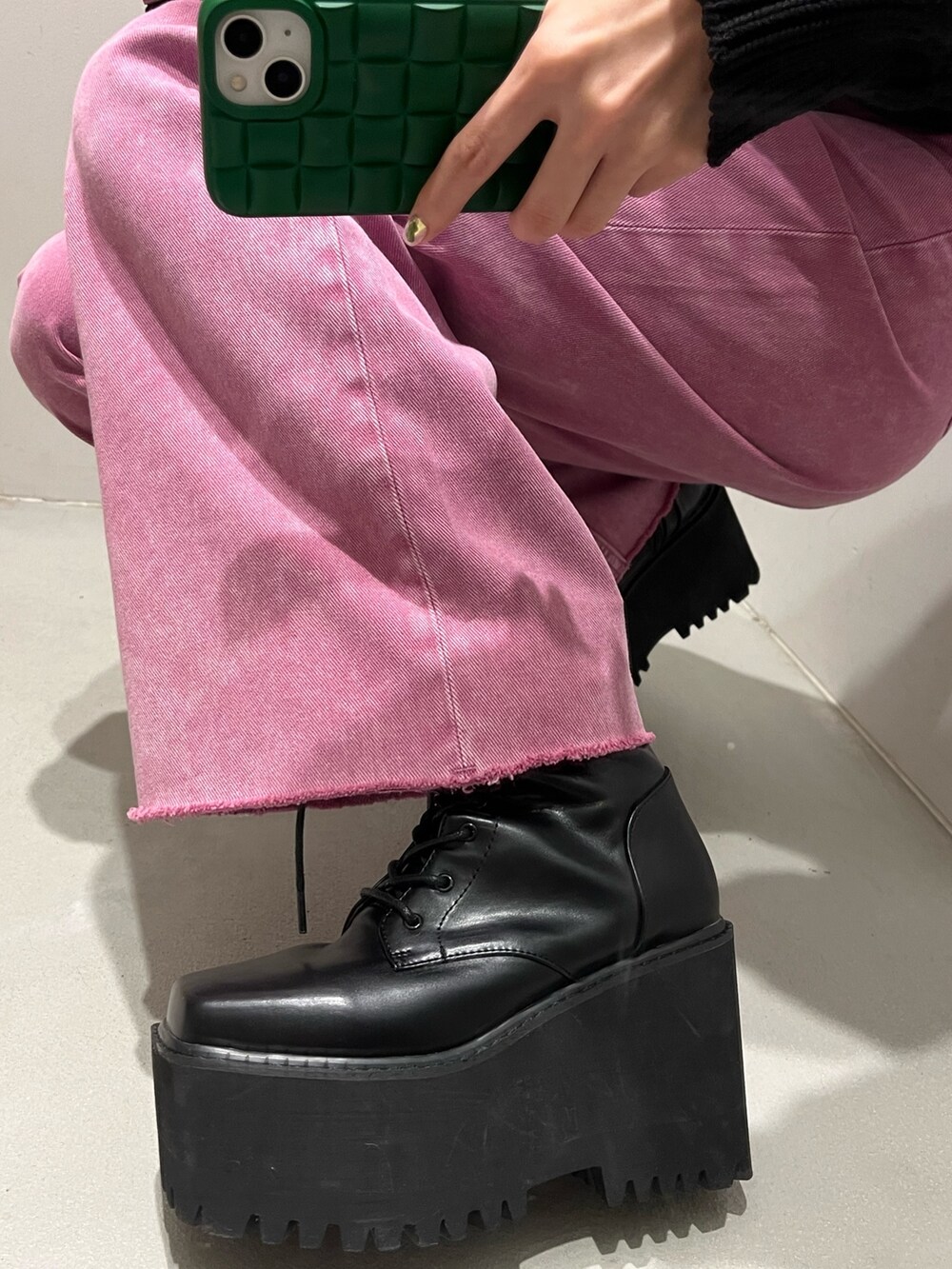 ピンク系のデニムパンツ、ブラック系のニット/セーター、ブルー系のショルダーバッグを着用したレディースの冬コーディネートの5枚目の写真