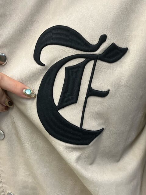 ブラック系のワンピース、ブラック系のブーツ、ベージュ系のブルゾンを着用したレディースの秋コーディネートの7枚目の写真