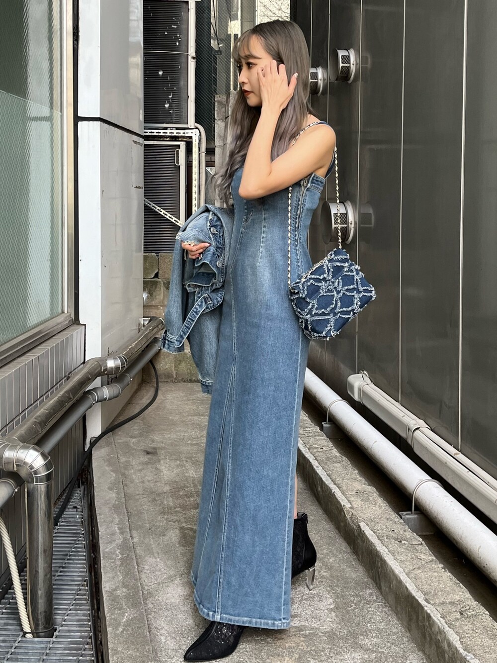 ブルー系のデニムジャケット、ブルー系のワンピース、ブルー系のショルダーバッグを着用したレディースの冬コーディネートの3枚目の写真