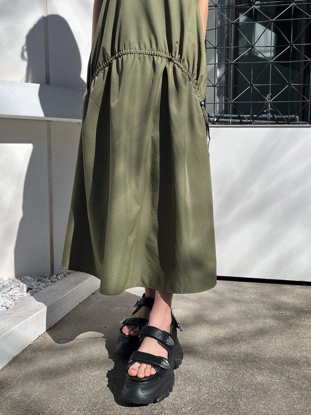 グリーン系のワンピース、ホワイト系のサンダルを着用したレディースの春コーディネートの6枚目の写真