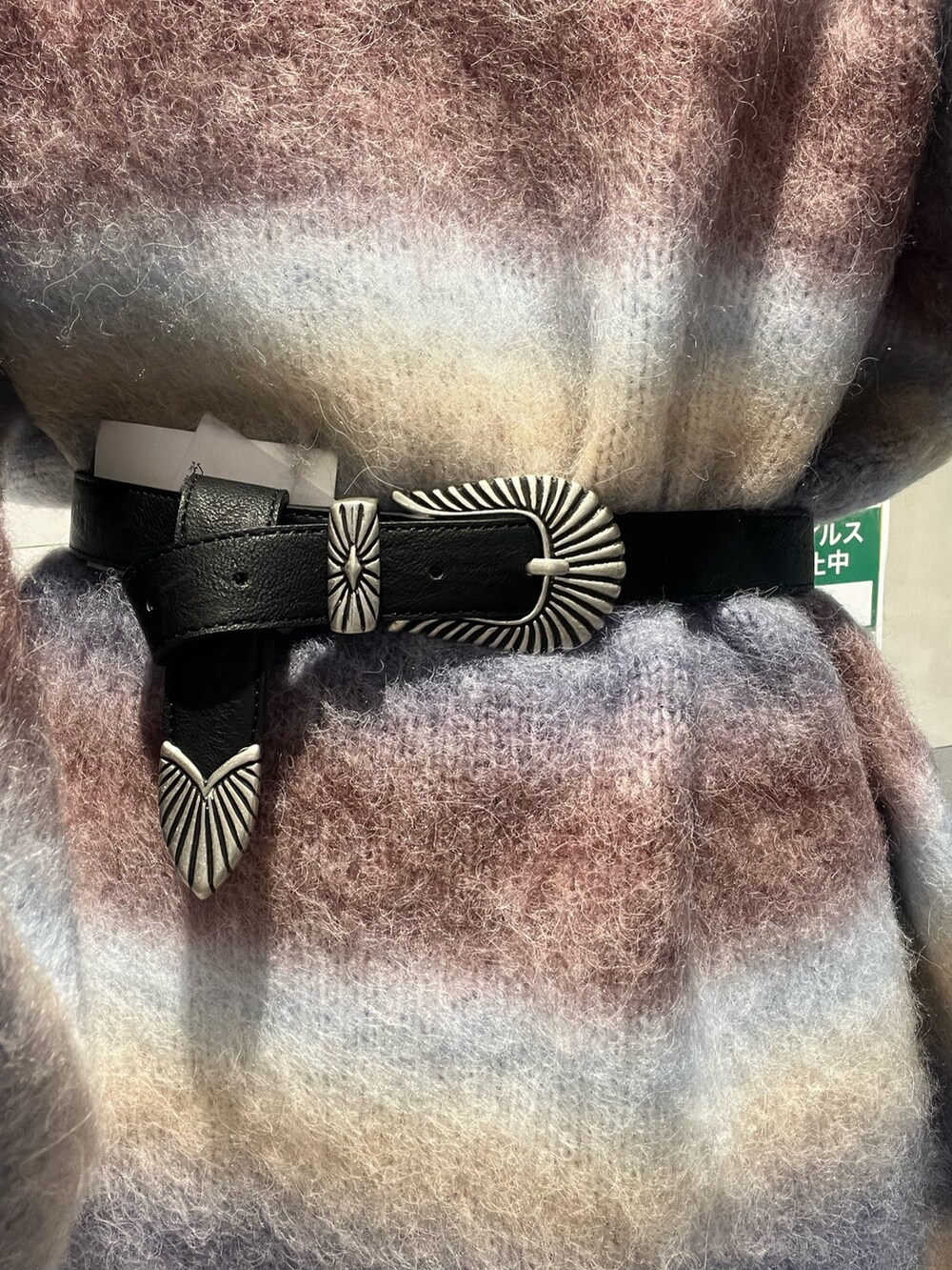 パープル系のニット/セーター、ブラック系のブーツ、ブラック系のベルトを着用したレディースの冬コーディネートの5枚目の写真