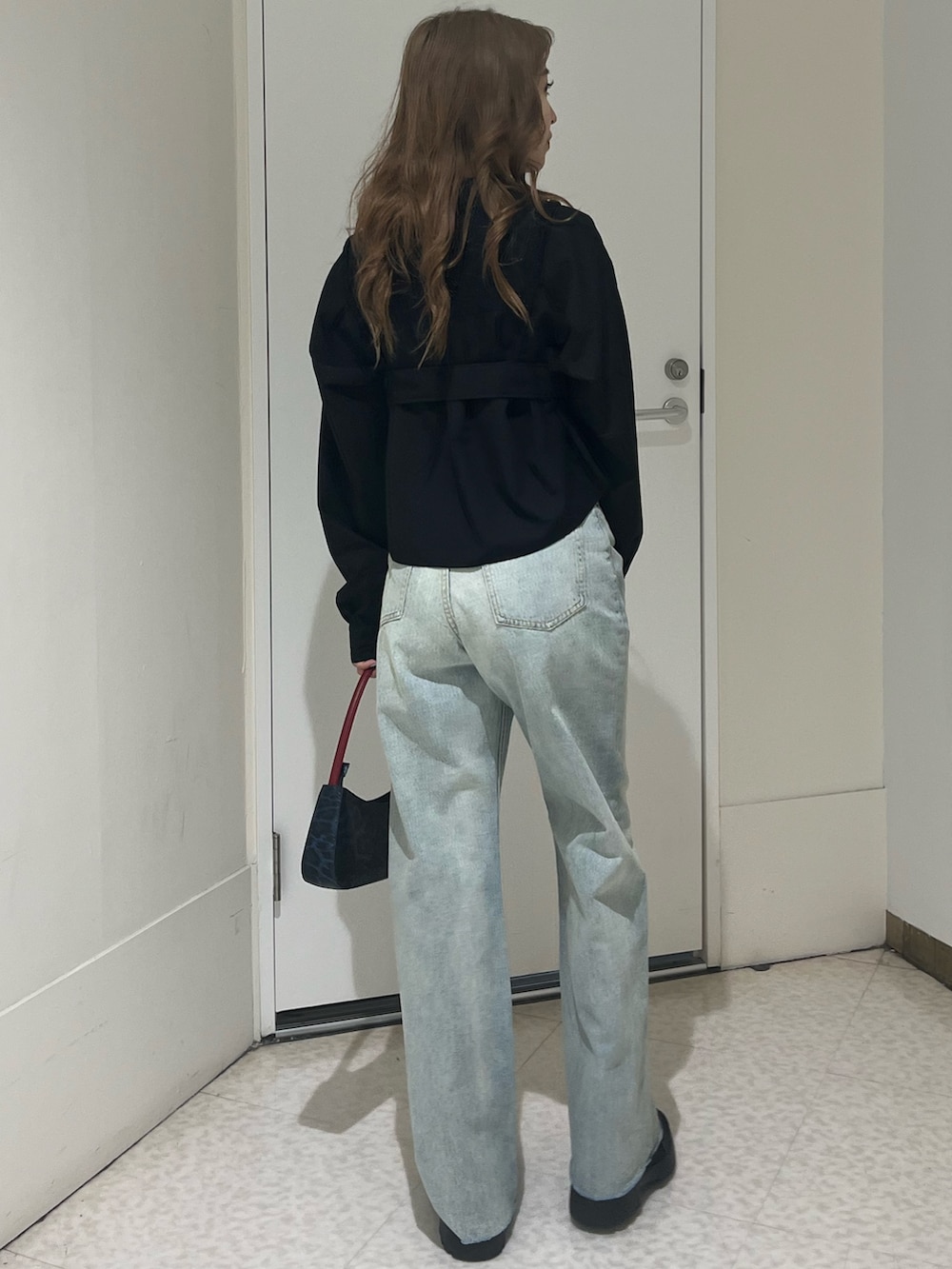 ブラック系のシャツ/ブラウス、ブルー系のデニムパンツ、ブラウン系のハンドバッグを着用したレディースの春コーディネートの3枚目の写真