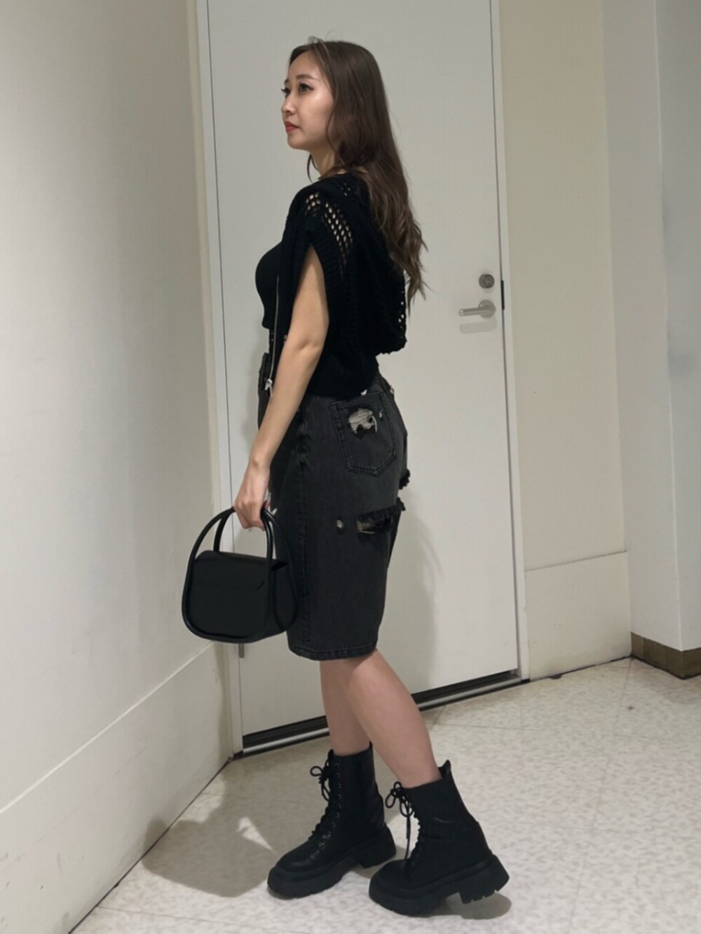 ブラック系のブーツ、ブラック系のハンドバッグ、ブラック系のキャミソールを着用したレディースの夏コーディネートの2枚目の写真