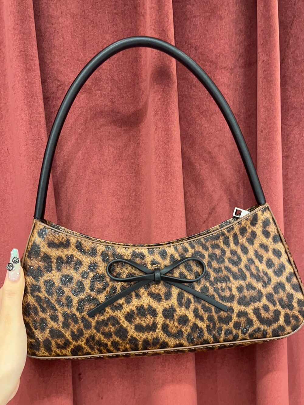 ブラウン系のハンドバッグ、ブラック系のブーツ、ブラック系のワンピースを着用したレディースの夏コーディネートの7枚目の写真