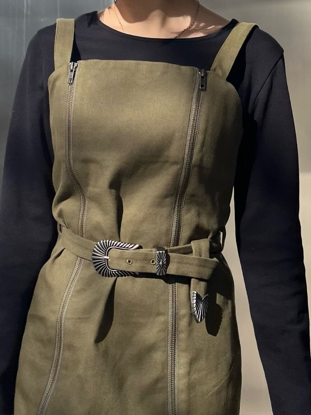 ブラック系のワンピース、ブラック系のショルダーバッグ、ブラック系のブーツを着用したレディースの冬コーディネートの5枚目の写真