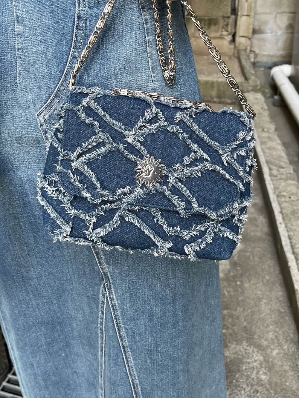 ブルー系のデニムジャケット、ブルー系のワンピース、ブルー系のショルダーバッグを着用したレディースの冬コーディネートの8枚目の写真