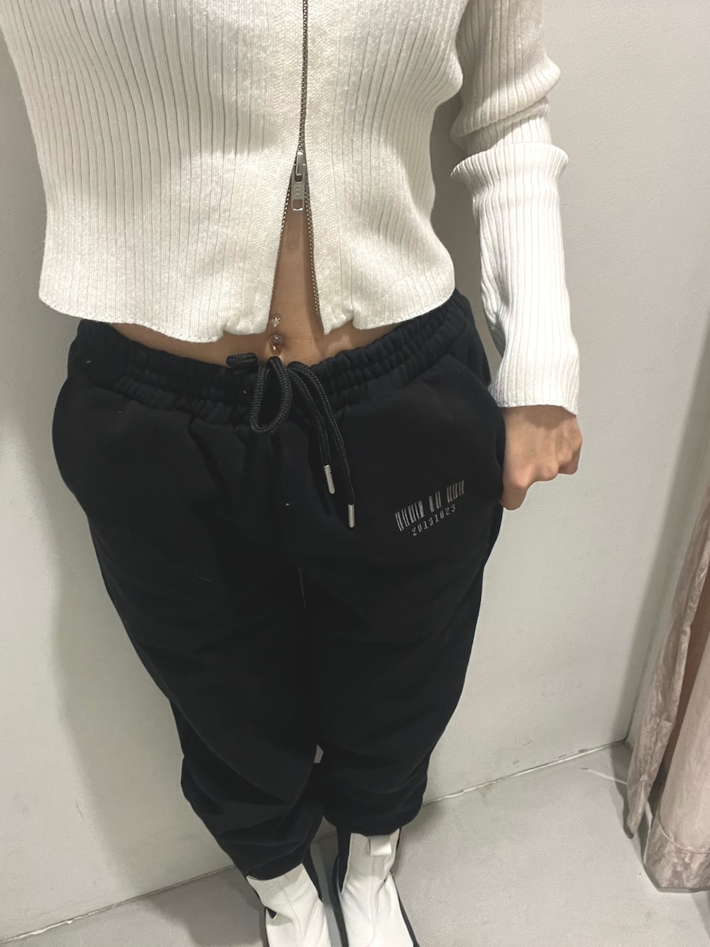 ブラック系のスウェットパンツ、ホワイト系のブーツ、ホワイト系のニット/セーターを着用したレディースの冬コーディネートの5枚目の写真